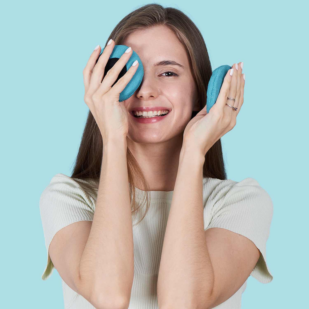 Smiling woman holding two circular blue Manta COOL Eye Cups.